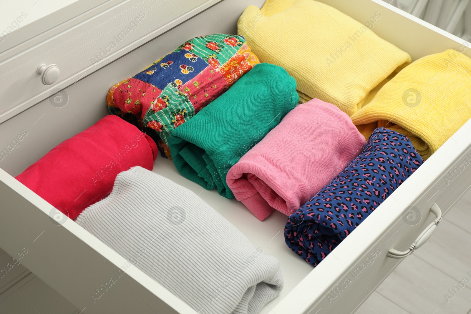 Photo of Folded clothes in open drawer. Apparel storage