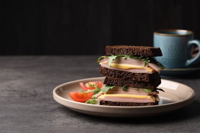 Photo of Delicious sandwiches with boiled sausage, tomato, cheese and arugula on grey table, space for text