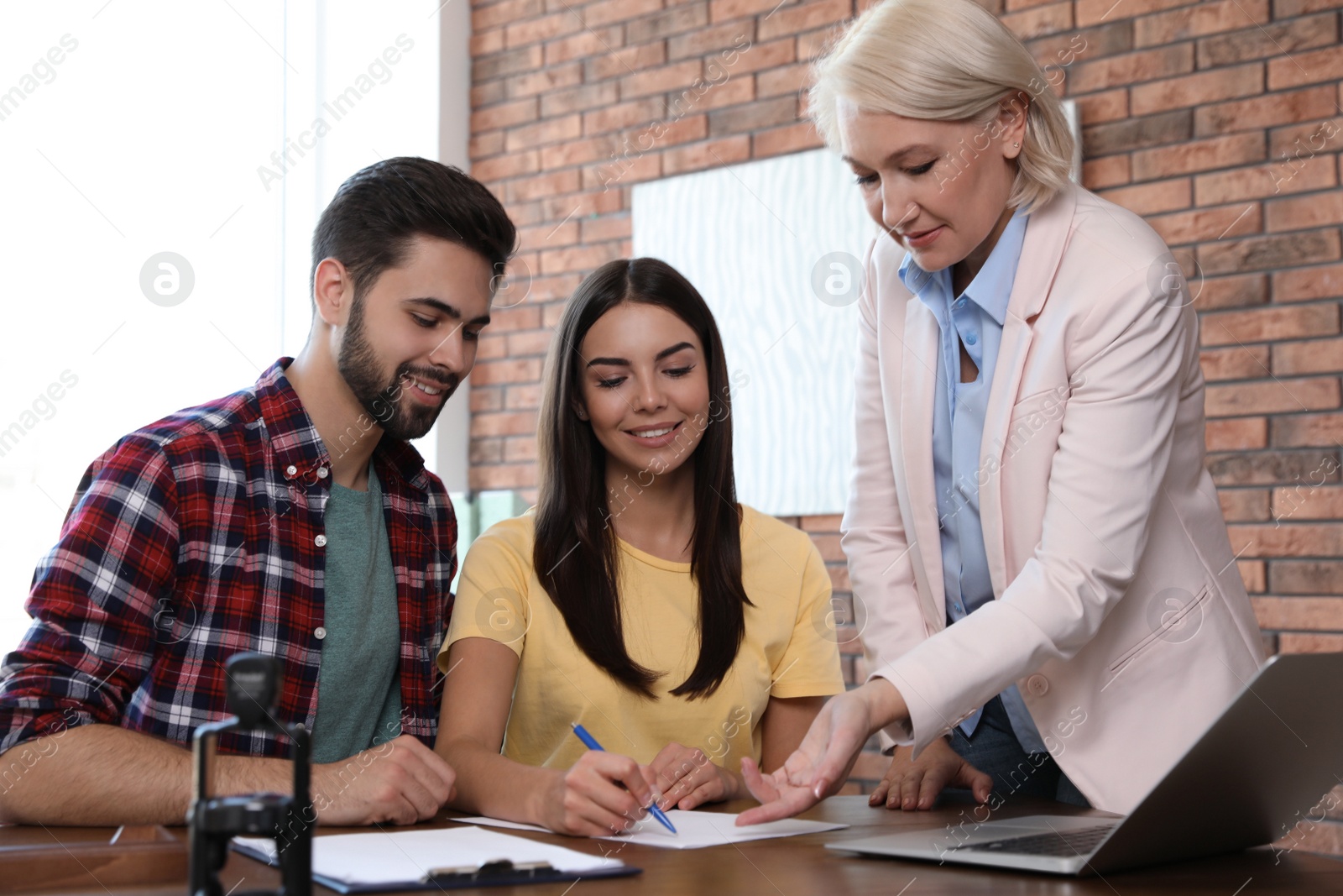 Photo of Female notary working with young couple in office