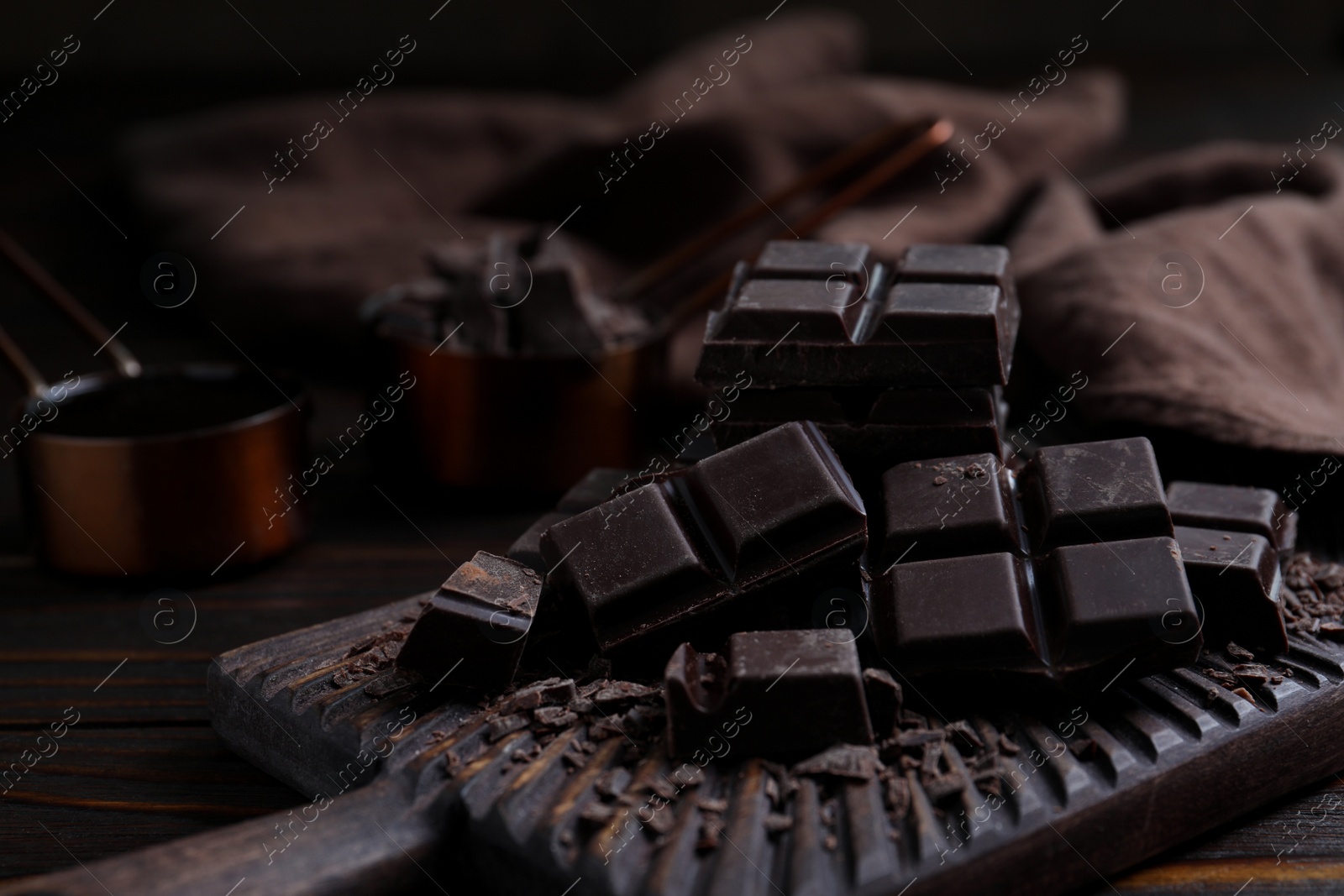 Photo of Delicious dark chocolate on wooden board, closeup