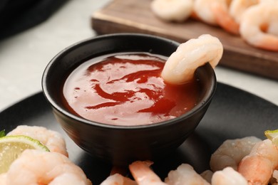 Photo of Tasty boiled shrimps with cocktail sauce and lime on table, closeup