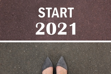 Image of Text Start 2021 on asphalt in front of woman, top view