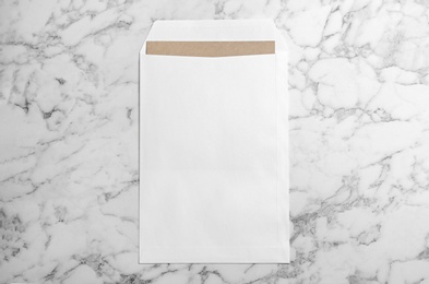 Photo of White paper envelope on marble background, top view