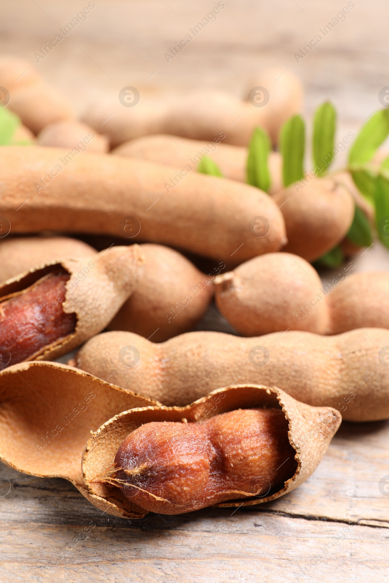 Photo of Delicious ripe tamarinds on wooden table, closeup