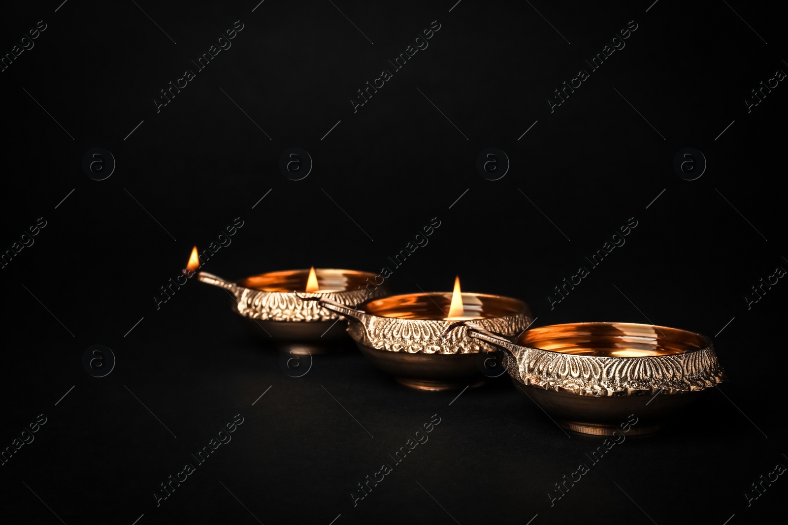 Photo of Diwali diyas or clay lamps on dark background