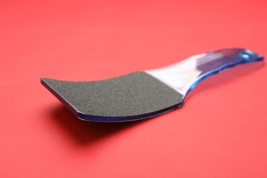 Photo of Blue foot file on red background. Pedicure tool