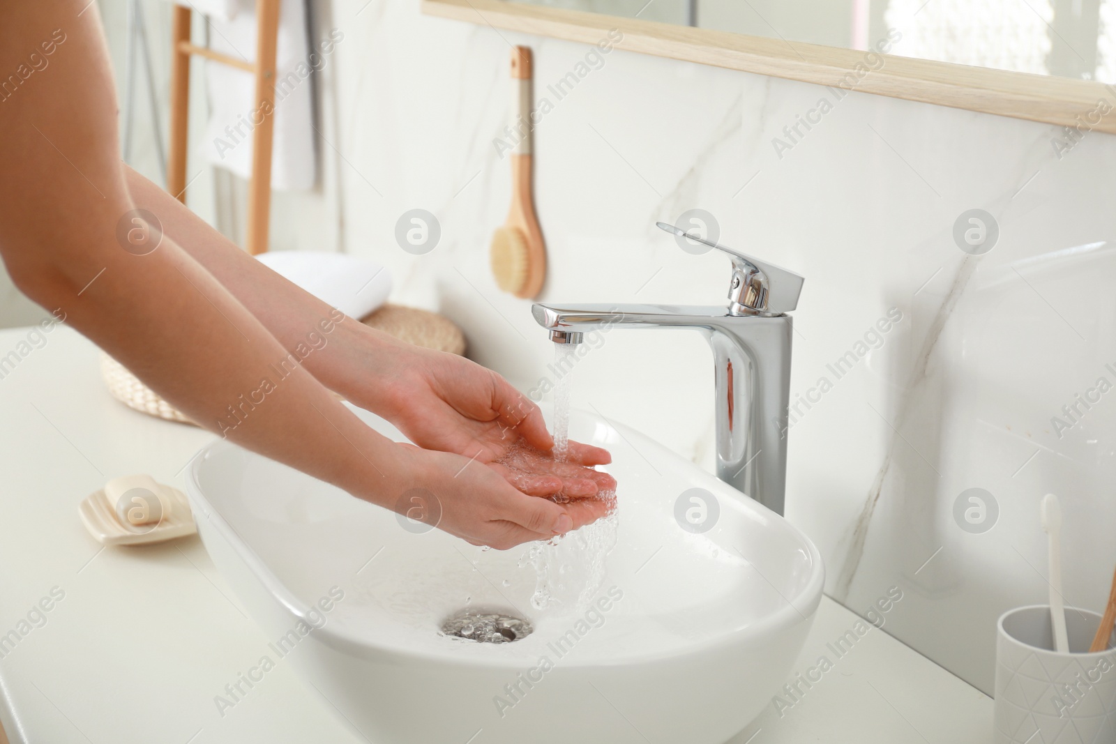 Photo of Woman washing hands indoors, closeup. Bathroom interior