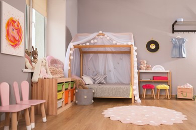 Photo of Stylish child room interior with comfortable house bed