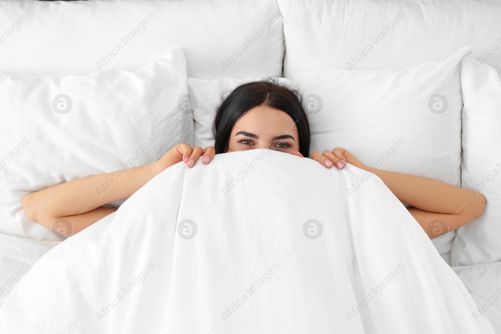 Photo of Young woman awakening at home, top view. Lazy morning