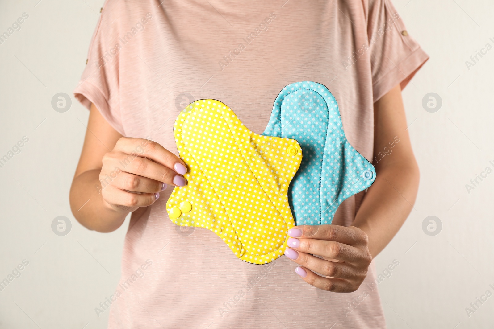 Photo of Woman holding reusable cloth menstrual pads isolated on white, closeup