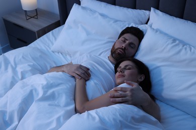 Photo of Lovely couple sleeping together in bed at night