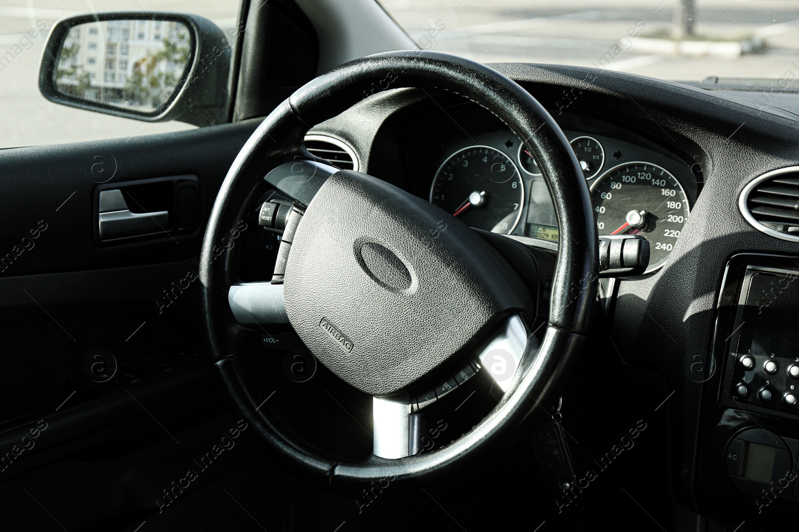 Photo of Black steering wheel and dashboard in car