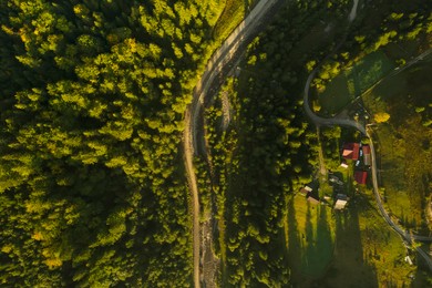 Image of Aerial view of landscape with river, road and village surrounded by green trees. Drone photography