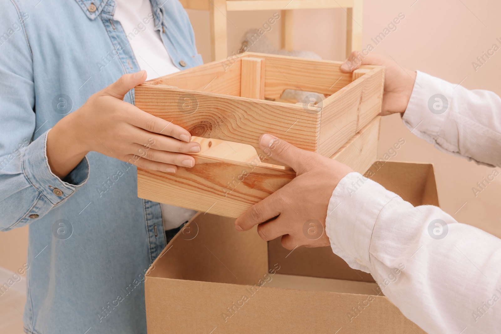 Photo of Happy couple unpacking box in new apartment, closeup. Moving day