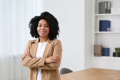 Smiling young businesswoman in office. Space for text