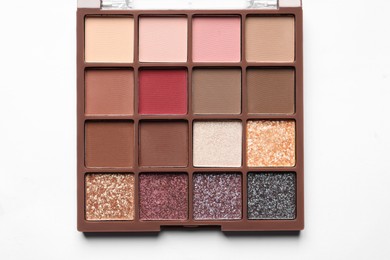 Photo of Beautiful eye shadow palette on white table, top view