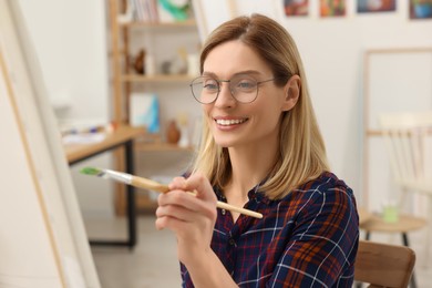 Woman painting on canvas in studio. Creative hobby