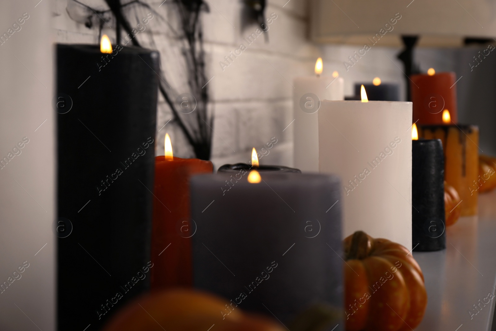 Photo of Burning candles and different Halloween decor indoors