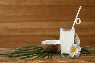 Composition with glass of coconut water on wooden background. Space for text