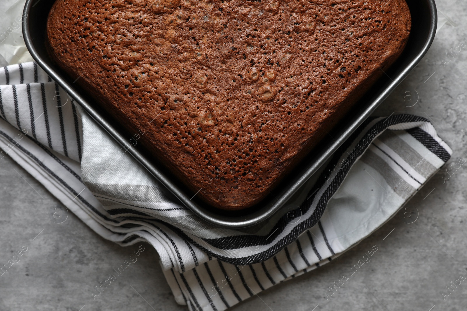 Photo of Homemade chocolate sponge cake on light grey table, top view