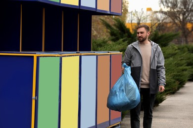 Photo of Man throwing garbage at recycling point outdoors