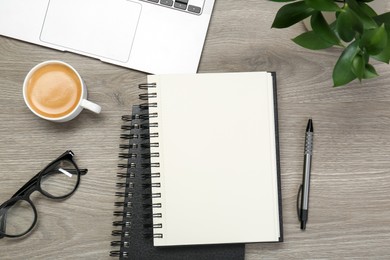 Photo of Flat lay composition with notebooks and laptop on wooden table