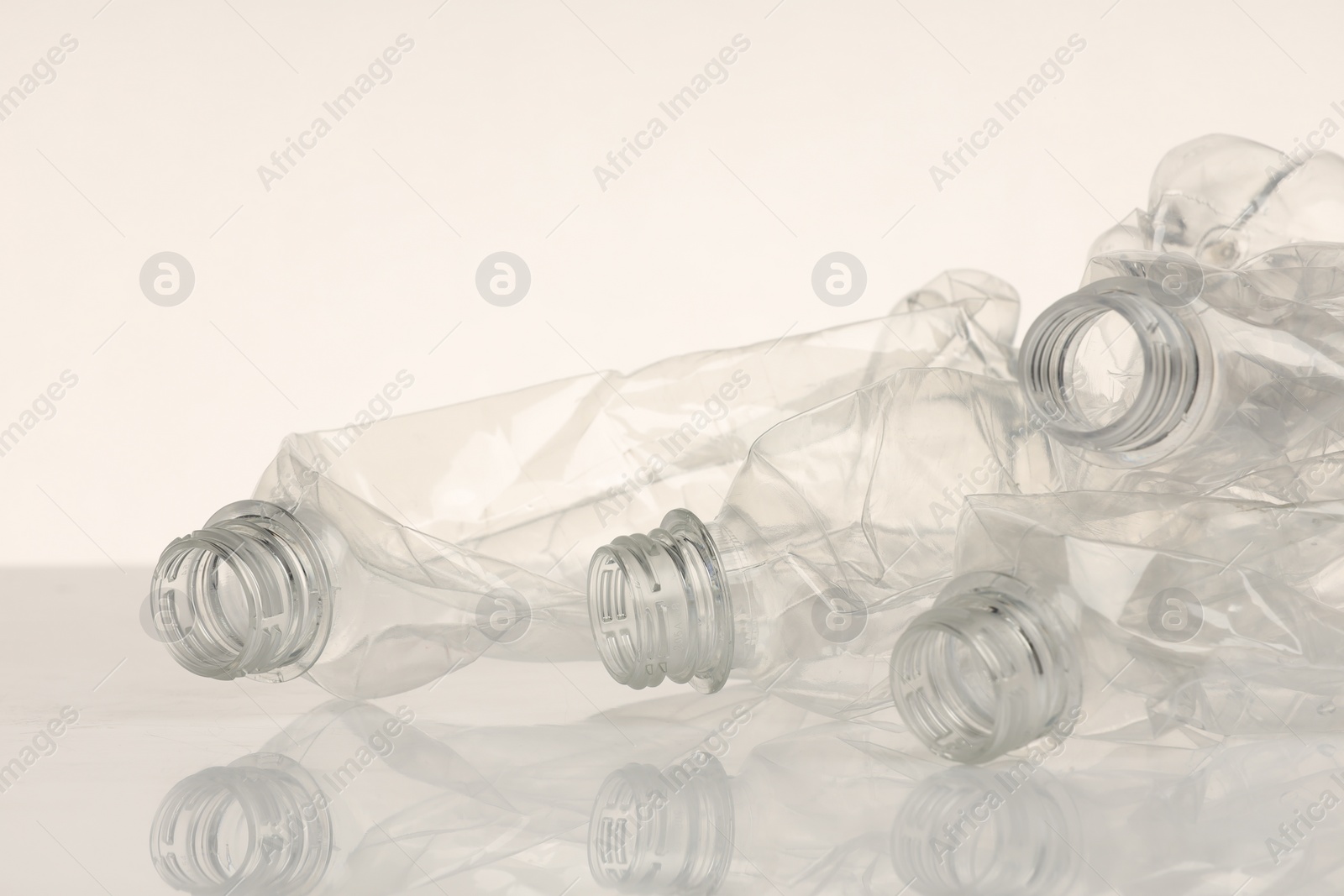 Photo of Crumpled disposable plastic bottles on white background