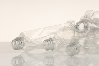 Photo of Crumpled disposable plastic bottles on white background