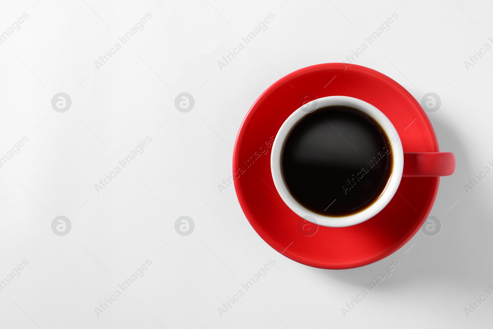 Photo of Cup with aromatic coffee on white background, top view. Space for text