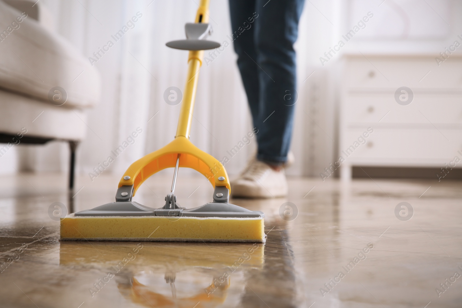 Photo of Woman cleaning parquet floor with mop indoors, closeup. Space for text