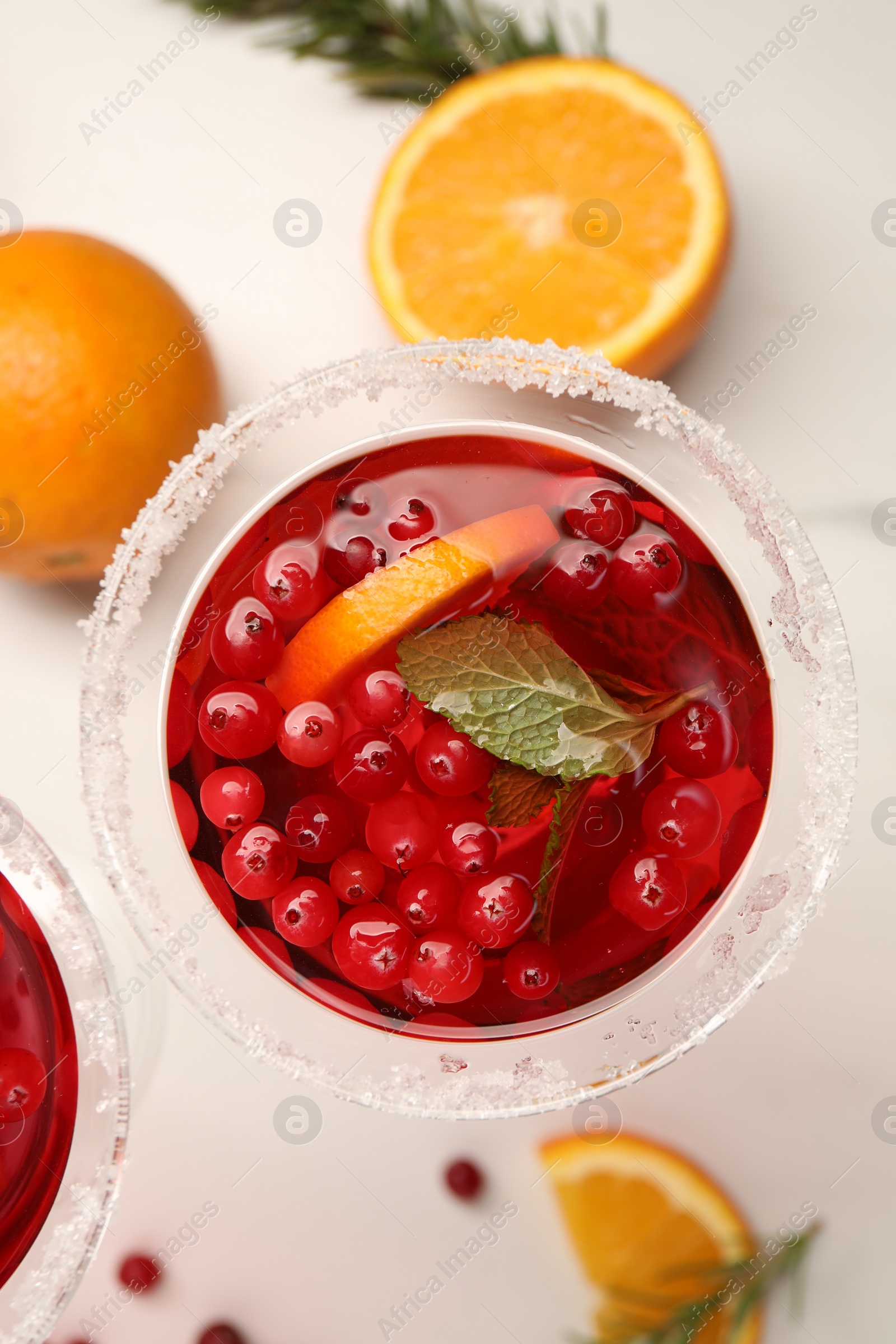 Photo of Tasty cranberry cocktail in glass on white table, flat lay