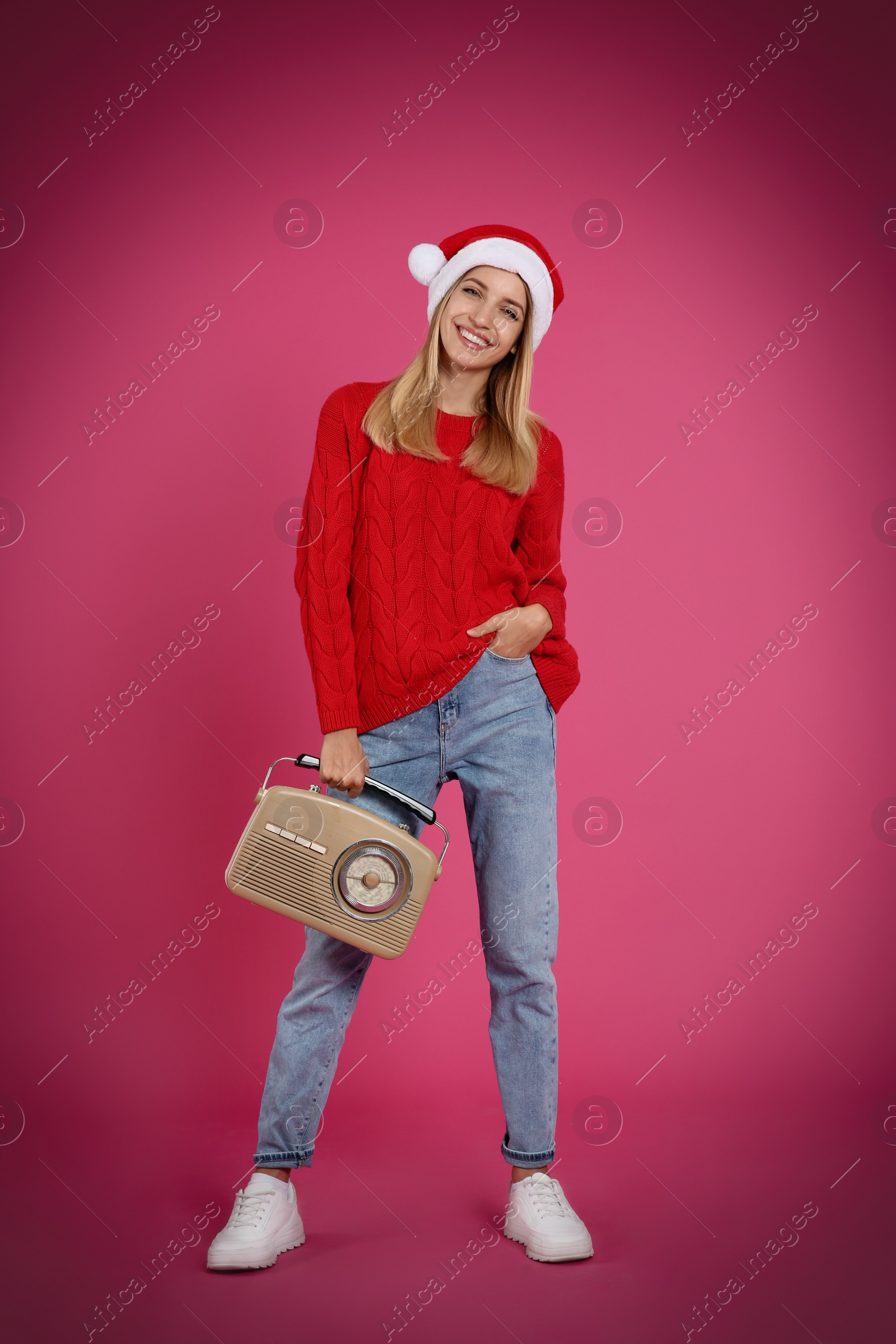 Photo of Happy woman with vintage radio on pink background. Christmas music