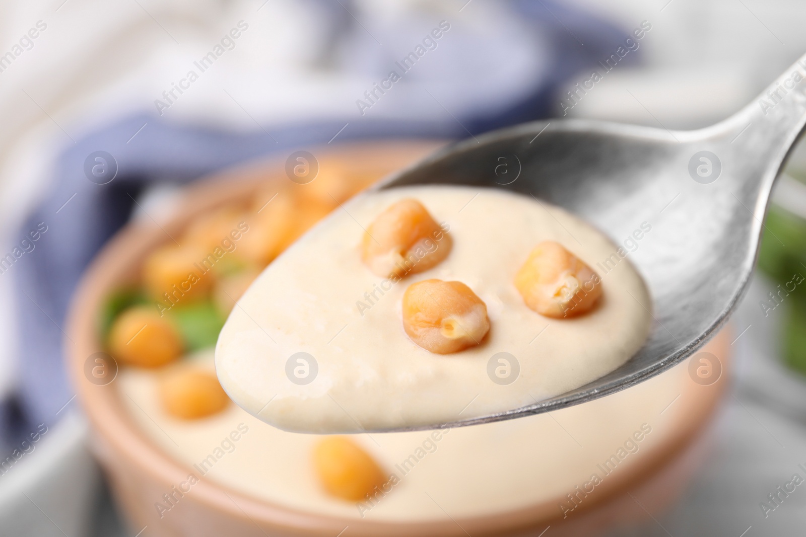 Photo of Eating tasty chickpea soup on table, closeup