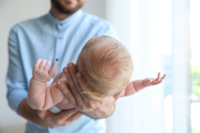 Photo of Father holding his newborn baby at home, closeup