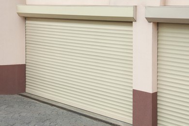 Building with white roller shutter garage doors