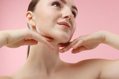 Photo of Beautiful woman touching her chin on pink background