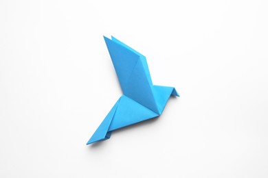 Photo of Beautiful blue origami bird on white background, top view