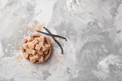 Photo of Bowl with brown vanilla sugar on grey background, top view