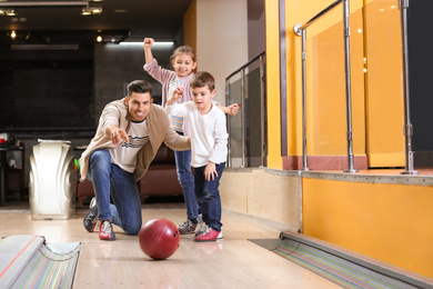 Photo of Happy family spending time together in bowling club