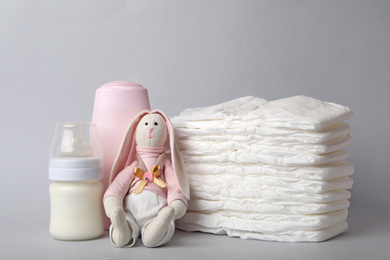 Photo of Diapers and baby accessories on light grey background