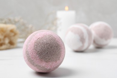 Pink bath bomb on white table, closeup. Space for text