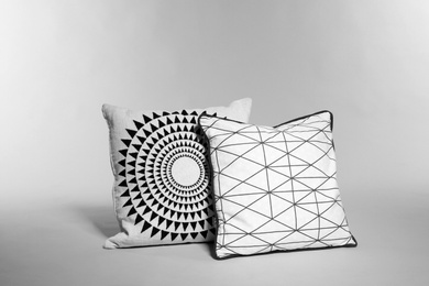 Photo of Two stylish decorative pillows on light background