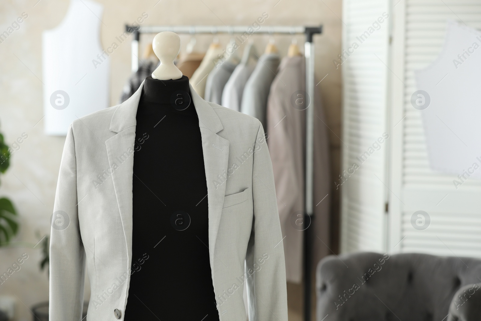 Photo of Mannequin with stylish jacket in tailor shop, space for text