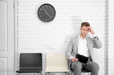 Photo of Young man waiting for job interview, indoors