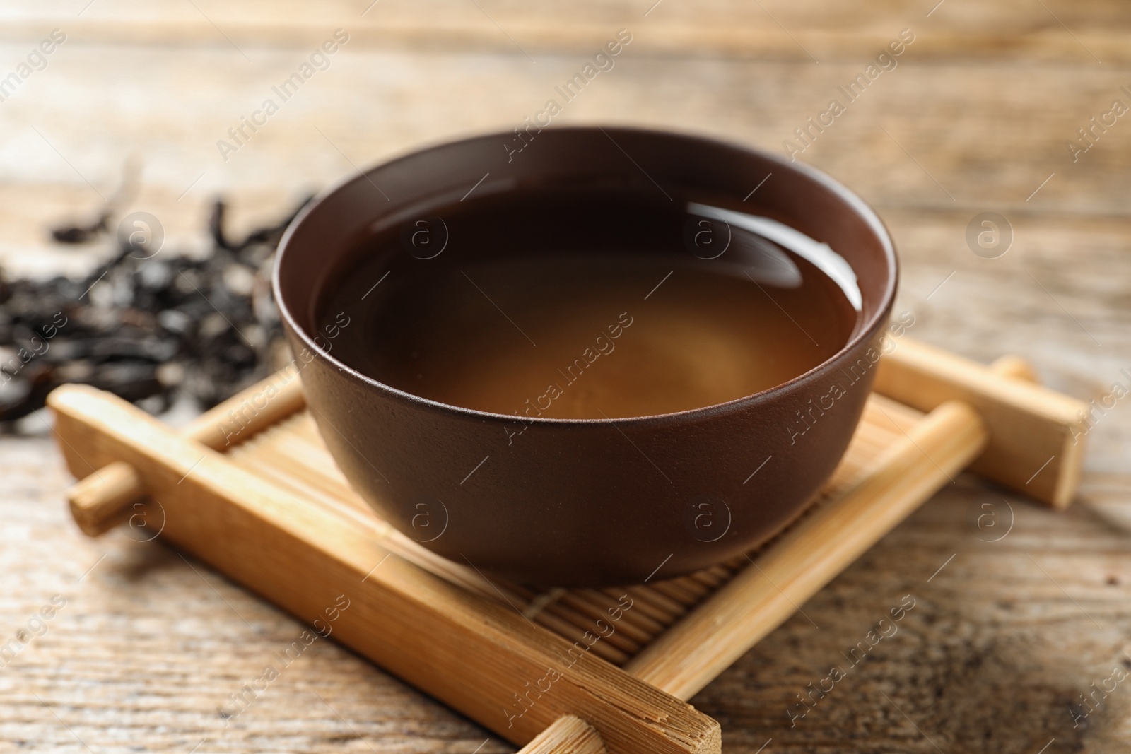 Photo of Cup of Da Hong Pao oolong and tea leaves on table