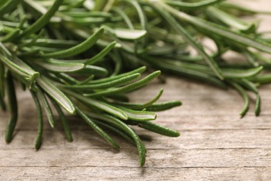 Photo of Sprigs of fresh rosemary on wooden table, closeup