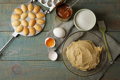 Photo of Freshly baked homemade walnut shaped cookies, dough and ingredients on wooden table, flat lay