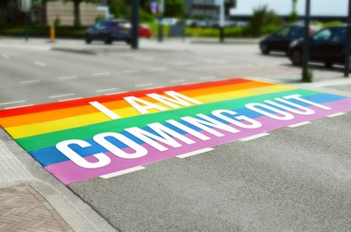 Rainbow flag with text I Am Coming Out on asphalt road