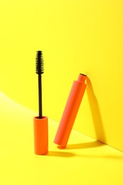 Photo of Mascara for eyelashes on yellow background. Makeup product