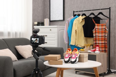Fashion blogger's workplace. Shoes, clothes, camera and stylish furniture indoors